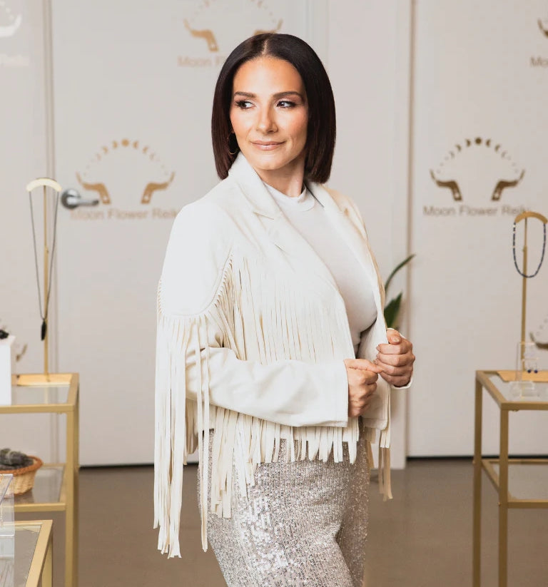 Woman wearing a white fringe jacket in a room with branded decor